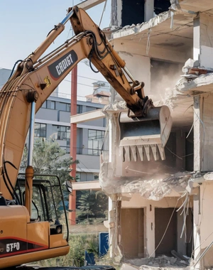 Excavator demolishing residential building structure Safe Demo Dallas demolition contractors Dallas