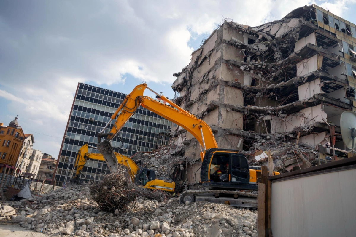 Safe Demo Dallas commercial demolition project with excavators tearing down large building structure in urban area