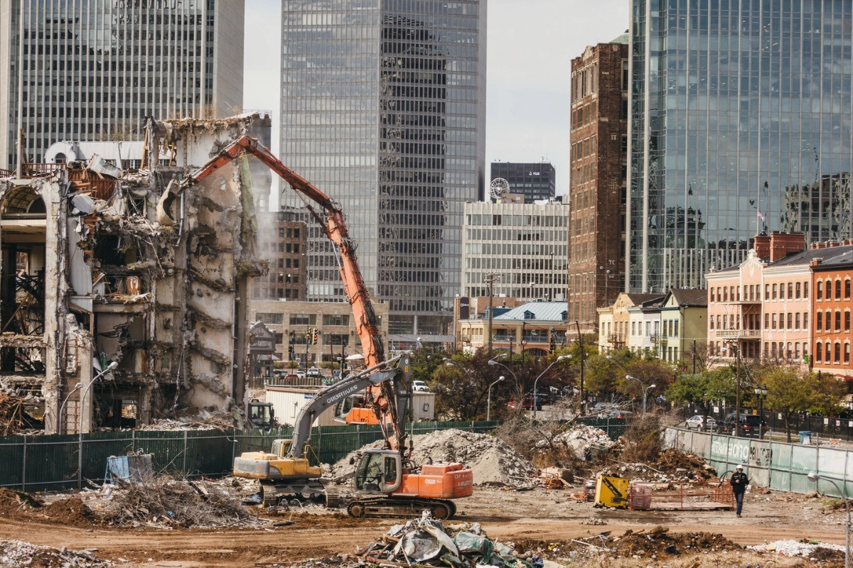 Safe Demo Dallas commercial demolition site with heavy machinery removing multi-story structure in city environment