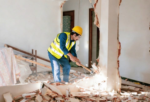 Safe Demo Dallas worker performing interior demolition using tools for controlled wall removal