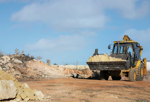Safe Demo Dallas land clearing with loader moving soil and debris for site preparation